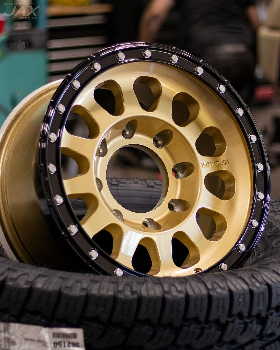 Gold Method off-road wheel on a stack of all-terrain tires at Jax Motorsports