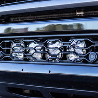 Close-up of 4 Baja Designs XL lights sitting behind the factory bumper grille on a Ram 2500/3500 with the JAX MFG mount