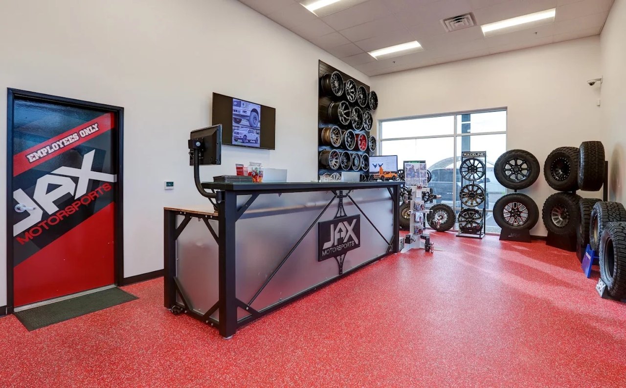 Jax Motorsports showroom interior with service counter, JAX branding, and wheel and tire displays