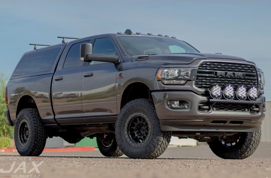 Lifted 2024 Ram 2500 Cummins Big Horn on a 3.25-inch Carli Back Country suspension with Innov8 G600 wheels, Toyo AT3 37s and a custom bull bar with four Baja Designs LP9 lights, built by Jax Motorsports