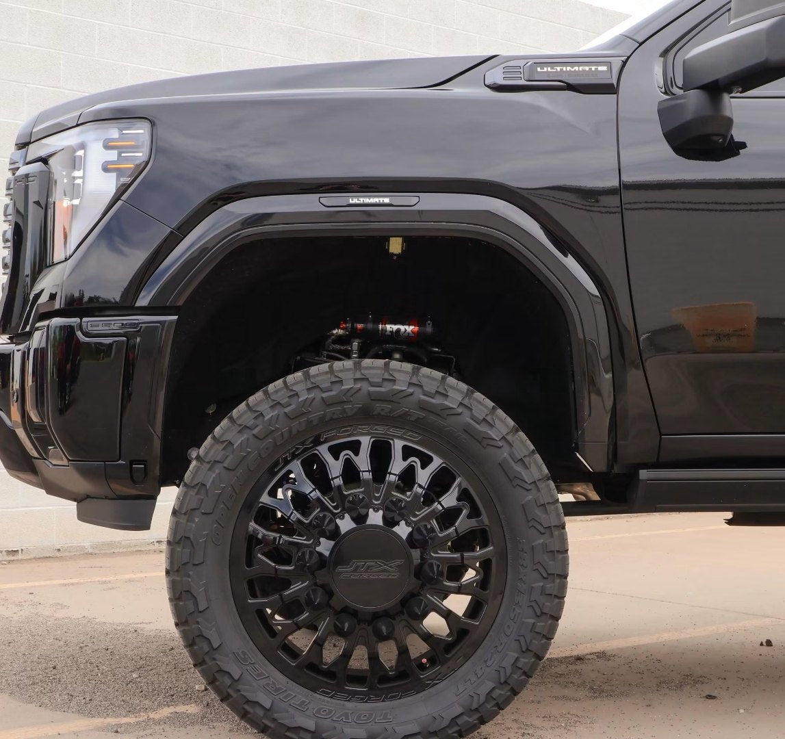 Close-up of the front JTX Forged wheel, Toyo tire and Fox shock on the black GMC dually