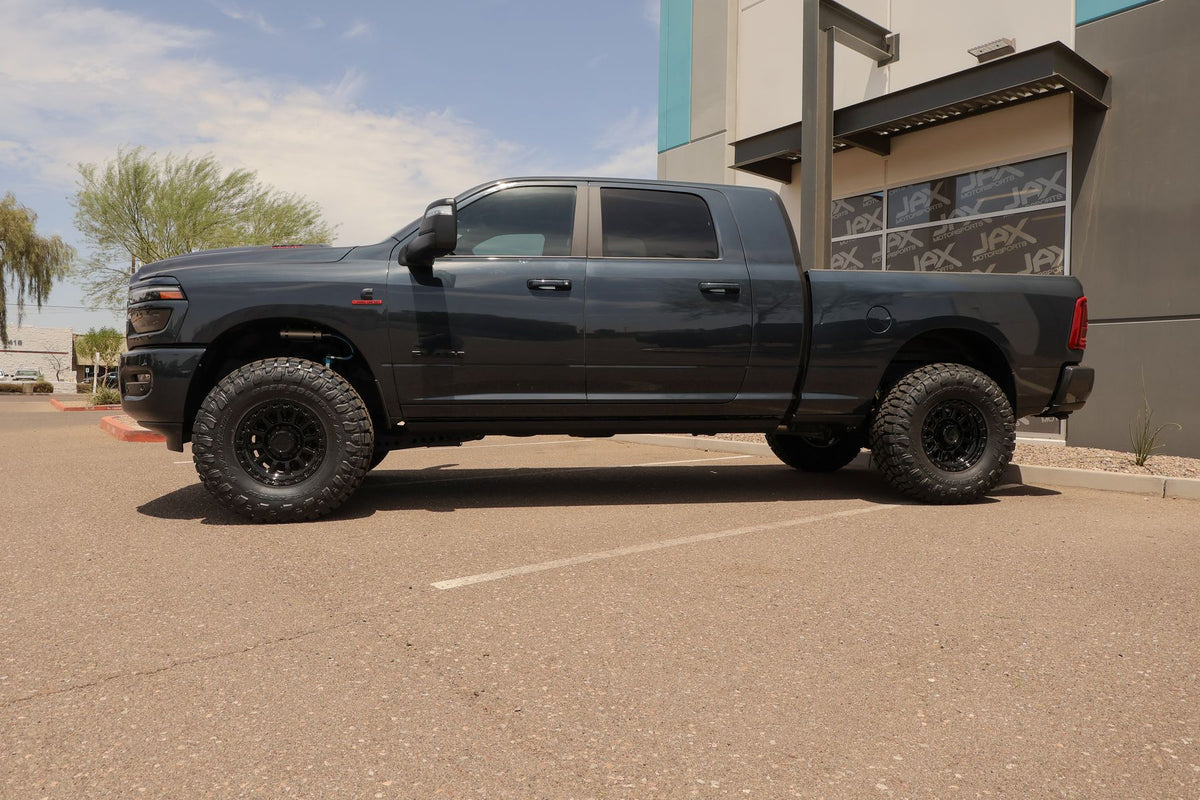Side profile of the lifted Ram 2500 Mega Cab in front of the Jax Motorsports shop