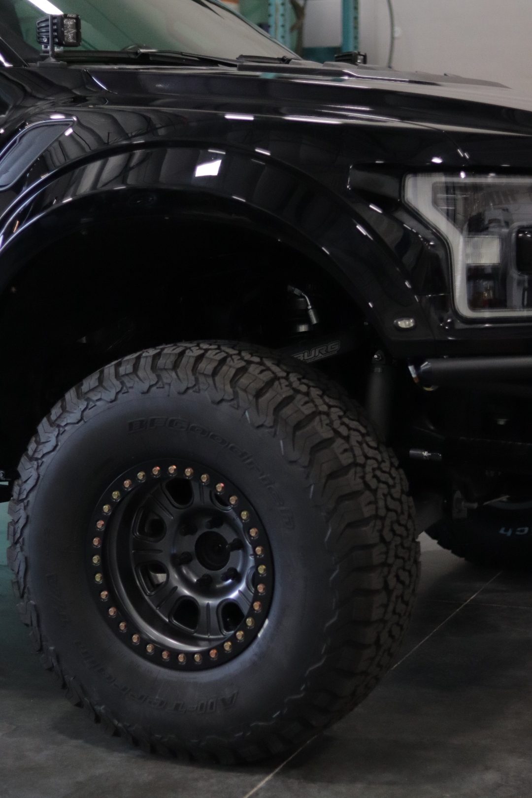 Wheel and suspension detail showing Camburg control arms and a 37-inch BFG KO2 tire