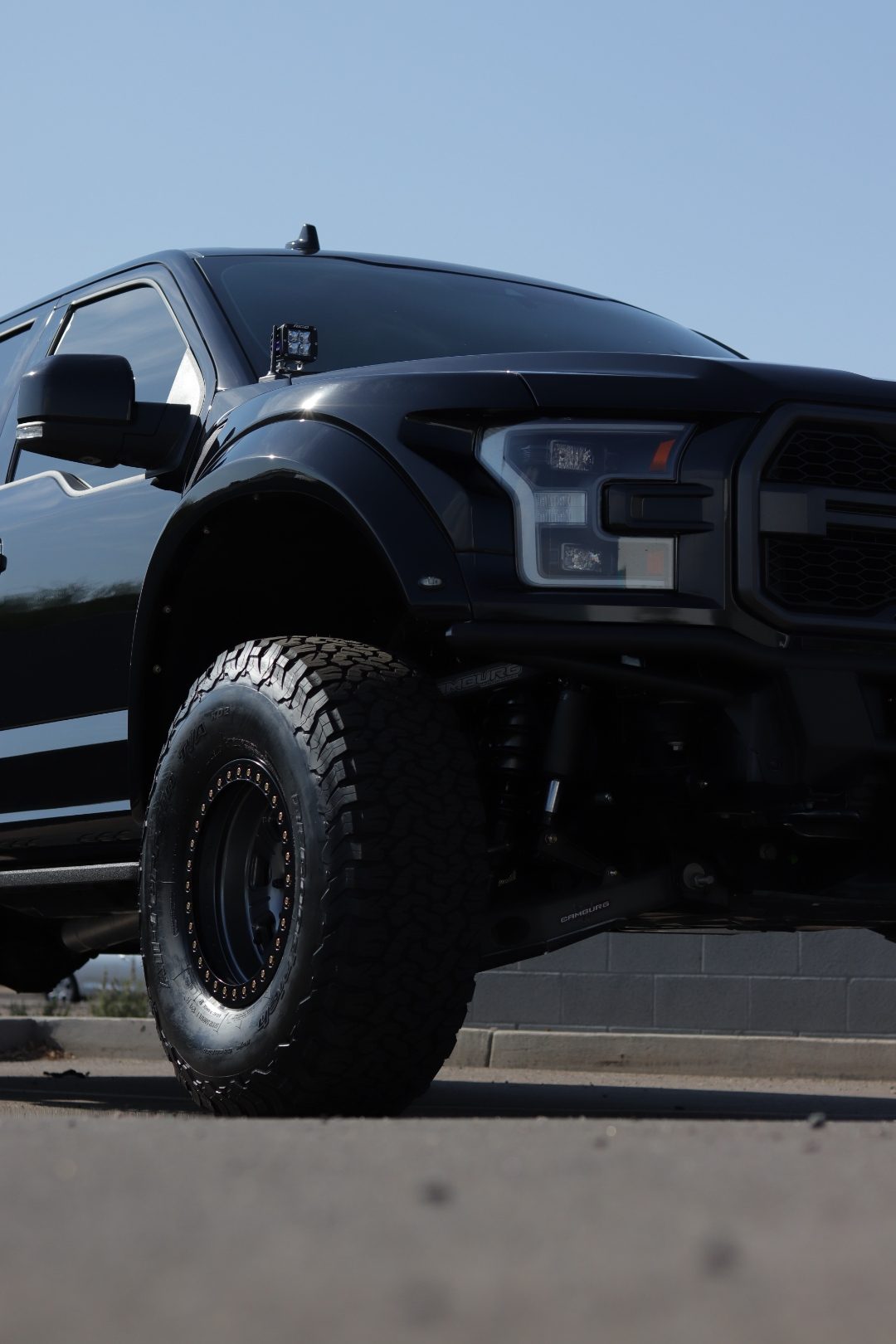 Low-angle detail of the F-150 Raptor front long-travel suspension and 37-inch KO2 tire