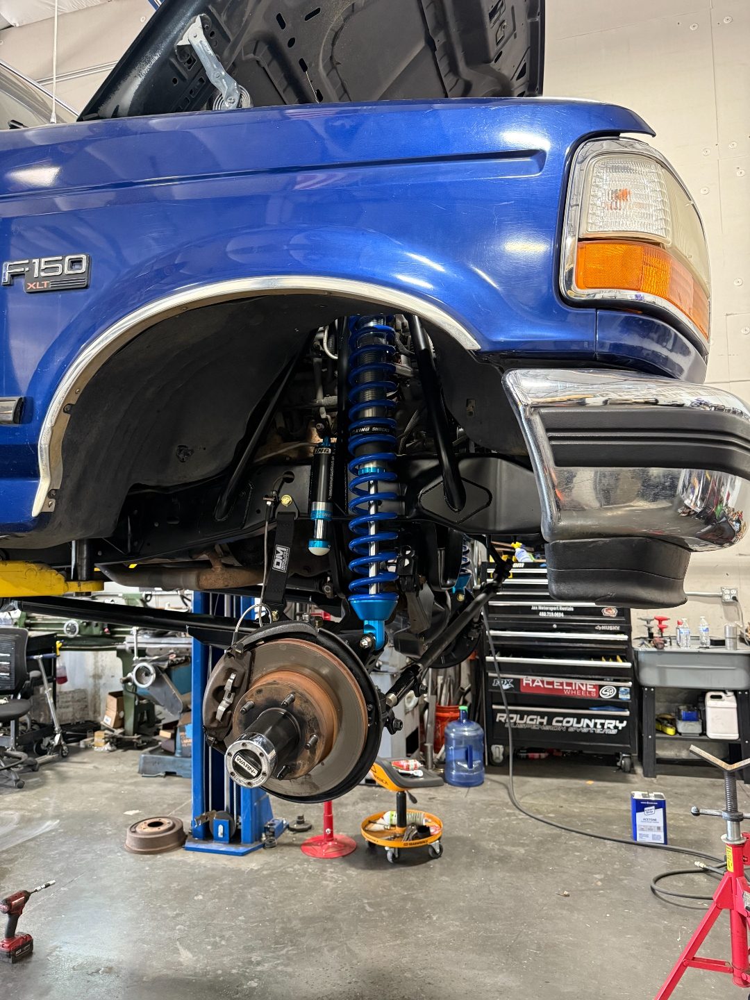 Three-quarter view of the front suspension showing the coilover mount, steering tie rods, and radius arms
